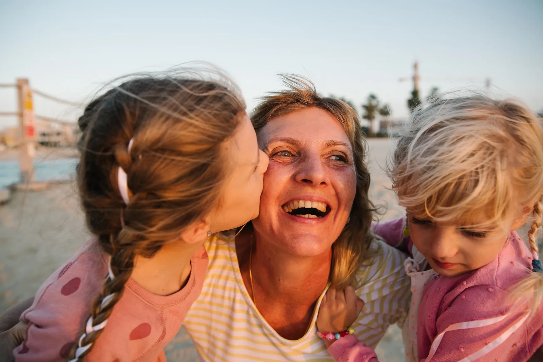 A grandmother smiling with her two granddaughters