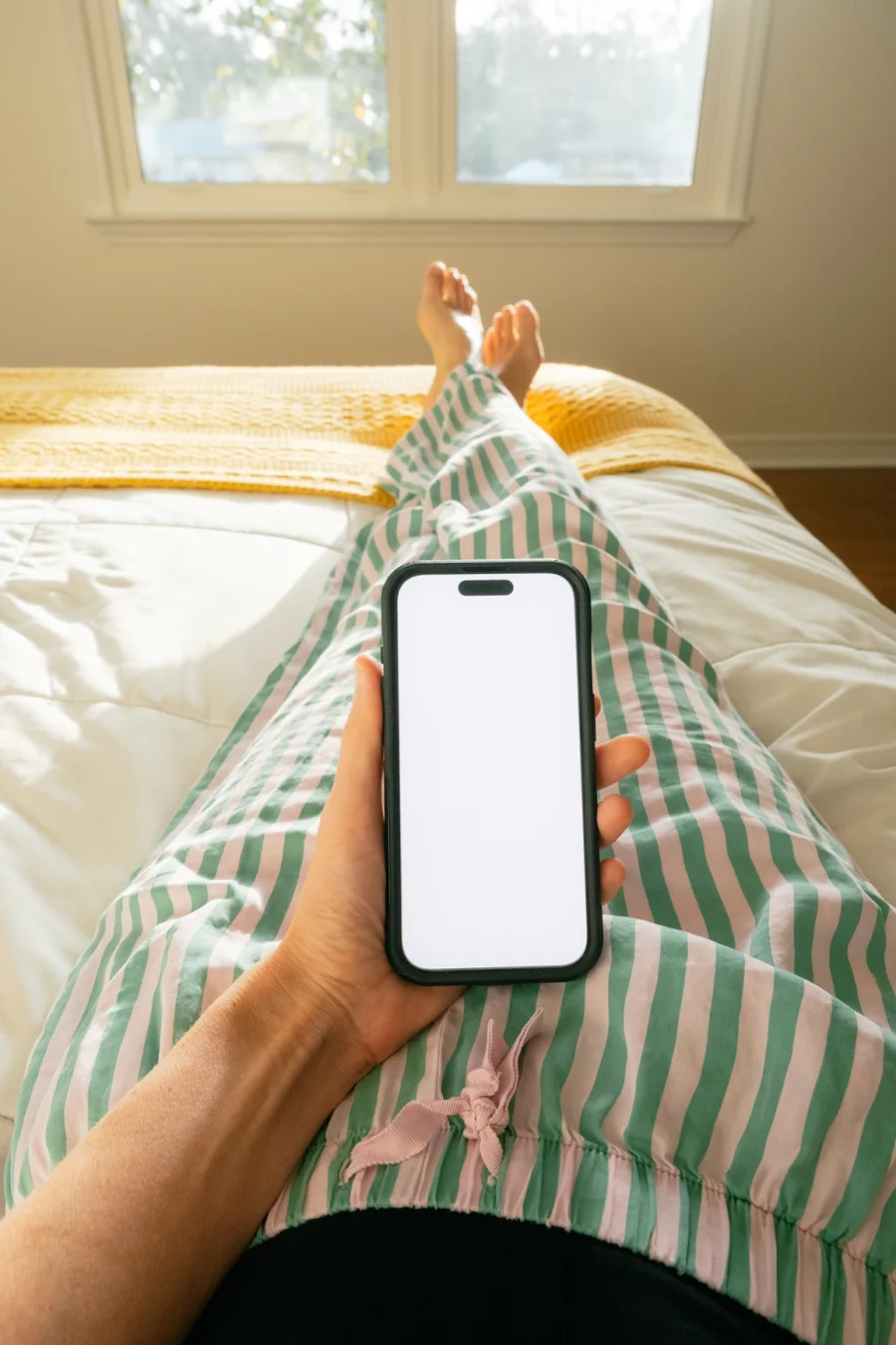 A person holding a phone while relaxing at home