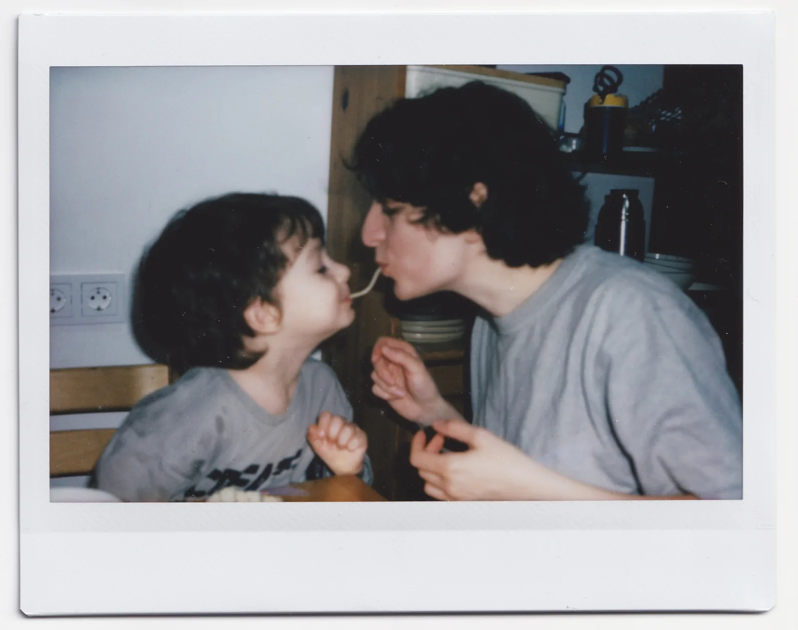 A mother and son sharing spaghetti